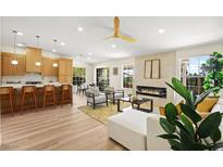 Bright living room with a fireplace, modern furnishings, and an open layout to the kitchen and dining area at 5520 Cranwood Ct, Las Vegas, NV 89130