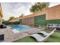 Inviting backyard pool area featuring lounge chairs, privacy landscaping, and comfortable seating for outdoor relaxation at 6021 Vista Clara St, Las Vegas, NV 89148