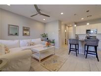 Bright living room with a comfortable white sofa, ceiling fan, and modern decor at 720 Sleeping City Ave, Henderson, NV 89015