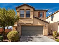 Two-story home with tan stucco, a two car garage, and desert landscaping at 8699 Grand Sequoia St, Las Vegas, NV 89139