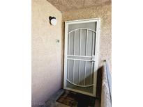 Welcoming condo entrance with security screen door and ample lighting at 221 Mission Newport Ln # 208, Las Vegas, NV 89107