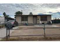 Modest single-story home with a chain-link fence and minimal landscaping, presenting a simple facade at 609 Kasper Ave, Las Vegas, NV 89106