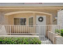 Inviting front entrance featuring white door with decorative wreath and a small gated porch area at 1153 Dusty Creek St, Las Vegas, NV 89128