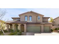 Charming two-story home featuring a tiled roof, arched entryway, and three-car garage at 12135 Kite Hill Ln, Las Vegas, NV 89138