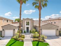 Beautiful two-story home featuring dual garages, a landscaped yard, and towering palm trees at 2690 Grassy Spring Pl, Las Vegas, NV 89135