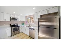 Bright kitchen features white cabinets, stainless steel appliances, and quartz countertops, offering a modern aesthetic at 3243 Savalli St # D, Las Vegas, NV 89102