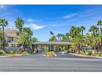 Welcoming community entrance featuring lush landscaping, palm trees and covered entry at 7115 S Durango Dr # 313, Las Vegas, NV 89113