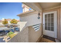 Charming condo entrance with private balcony, textured walls, and well-maintained landscaping in a desirable community at 7909 Fossil Creek Ln # 202, Las Vegas, NV 89145