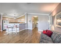Bright living room featuring an open layout with hardwood floors and a breakfast bar overlooking the kitchen at 7909 Fossil Creek Ln # 202, Las Vegas, NV 89145