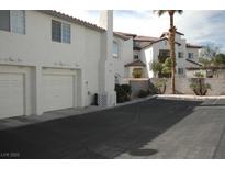 Charming condo building with attached garages, paved driveways, and simple desert landscaping at 8225 Belle Star Ct, Las Vegas, NV 89145