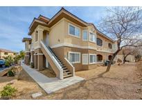 Inviting two-story condo building featuring a neutral color scheme, well-maintained landscaping, and convenient stair access at 833 Aspen Peak Loop # 712, Henderson, NV 89011