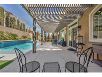 Relaxing covered patio with modern furniture and a beautiful view of the sparkling pool at 9781 Arcadian Estate Ct, Las Vegas, NV 89141