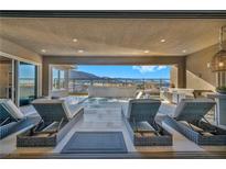 Inviting covered patio with a pool, spa, outdoor kitchen, and stunning mountain views at 10096 Amethyst Hills St, Las Vegas, NV 89148
