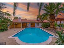 Backyard pool featuring a pristine pool with mature palm trees and beautiful tile work at 1561 Doran Dr, Las Vegas, NV 89123