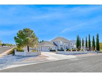Charming two-story home featuring a light gray exterior, concrete perimeter, and a well-maintained front yard at 241 E Country Club Dr, Henderson, NV 89015