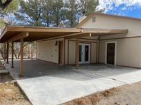 View of the home's exterior with a large covered parking area and multiple entrances at 4021 Jesse St, Pahrump, NV 89048