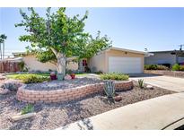 Charming single story home features a well-manicured front yard with mature trees and desert landscaping at 5109 Sugarfoot Ave, Las Vegas, NV 89107