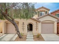 Inviting two-story home featuring a charming front yard, a two-car garage, and mature landscaping at 5453 Brass Hills Ct, Las Vegas, NV 89122