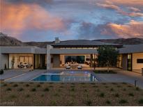 Stunning backyard pool with mountain views and open access to home's living spaces at sunset at 6 Rockmount Ct, Henderson, NV 89012