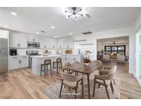Bright open kitchen with white cabinets, stainless appliances, an island and adjoining dining area at 617 Carpenter Dr, Las Vegas, NV 89107