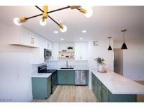 Bright kitchen featuring white cabinets, green lower cabinets and stainless steel appliances at 7932 Diamond Rock Way # 101, Las Vegas, NV 89128