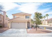 Charming two-story home featuring a tile roof, neutral stucco exterior, and a well-manicured front yard at 1653 Sun Canyon Ct, Las Vegas, NV 89128