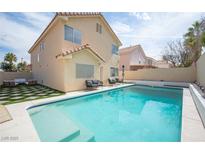 Inviting backyard pool area with lounge seating and well-maintained landscaping, perfect for outdoor relaxation at 1653 Sun Canyon Ct, Las Vegas, NV 89128