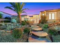 Inviting front entrance with stone walkway, mature landscaping, and a glimpse of the home's architectural details at 2062 Dipinto Ave, Henderson, NV 89052