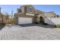Charming home featuring a two-car garage and an inviting gray brick driveway at 357 Stone Fly Rd, North Las Vegas, NV 89032