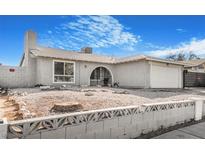 Charming single-story home featuring a stucco exterior, arched entrance, and low-maintenance gravel landscaping at 4303 E Viking Rd, Las Vegas, NV 89121