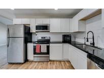 Bright kitchen with stainless steel appliances, white cabinets, and dark countertops at 4505 Providence Ln, Las Vegas, NV 89107