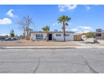 Charming single-story home featuring a well-maintained yard and desert landscaping, complemented by swaying palm trees at 4825 Randall Dr, Las Vegas, NV 89122