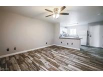 Inviting living room featuring stylish wood-look floors and a modern ceiling fan at 5326 Swenson St # 61, Las Vegas, NV 89119