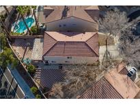 An aerial view shows the home with a pool, desert landscaping, and a brick-paved patio at 5516 Ness Ave, Las Vegas, NV 89118