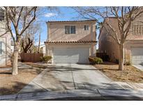 Two-story home featuring a large garage door and desert landscaping at 5516 Ness Ave, Las Vegas, NV 89118