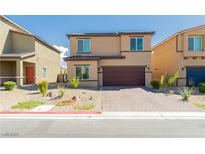 Inviting two-story home featuring a well-maintained front yard with desert landscaping and a two-car garage at 7322 Glimmer Point St, North Las Vegas, NV 89084