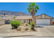 Charming single-story home featuring a palm tree in the front yard and a backdrop of picturesque mountains at 478 Potomac St, Henderson, NV 89015