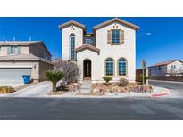 Two-story home featuring arched windows and desert landscaping at 9102 Brilliant Prairie Ct, Las Vegas, NV 89149