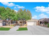 Charming single-story home featuring mature trees, a well-manicured lawn, and a spacious driveway at 2244 Garden City Ave, Henderson, NV 89052