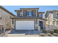 Charming two-story home featuring stone accents, a two-car garage, and manicured landscaping at 225 Sul Ponticello Ave, Las Vegas, NV 89011