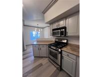 Well-lit kitchen featuring an oven and range with laminate counter tops and grey cabinets at 5525 W Flamingo Rd # 1020, Las Vegas, NV 89103