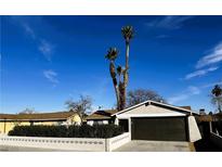 Charming single-story home featuring a well-kept yard, palm trees, and a two-car garage at , Las Vegas, NV 89121