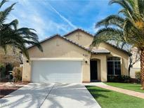 Charming single-story home featuring desert landscaping, a two-car garage, and lush palm trees enhancing curb appeal at 5213 Giallo Vista Ct, North Las Vegas, NV 89031