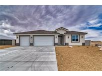 New construction home featuring a three car garage and desert landscaping at 6360 Montclair St, Pahrump, NV 89061