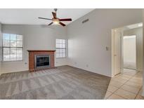 Inviting living room features a cozy brick fireplace and ceiling fan at 7719 Selby Ct, Las Vegas, NV 89147