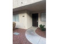 Inviting front entrance featuring a secure gate and well-maintained walkway and desert landscaping at 2667 Aracatuba Ave, Las Vegas, NV 89121