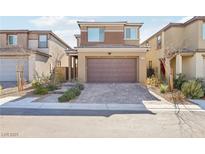 Two-story home with a two car garage, brick driveway, and desert landscaping at 354 Spotted Dove St, Las Vegas, NV 89138