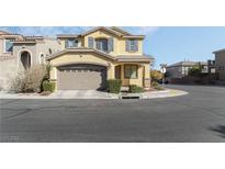 Two story home featuring tan stucco, two-car garage, stone accents, and well maintained front yard at 7222 Regent Pond St, Las Vegas, NV 89166