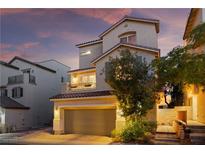 Charming stucco home featuring a two-car garage, balcony, and well-maintained landscaping at 10725 Wrigley Field Ave, Las Vegas, NV 89166