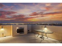 Enjoy city views and desert sunsets on this rooftop deck with an outdoor fireplace and modern glass table at 10725 Wrigley Field Ave, Las Vegas, NV 89166